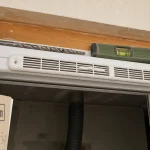 Grille aeration fenetre pvc sur traverse haute, pose et niveau